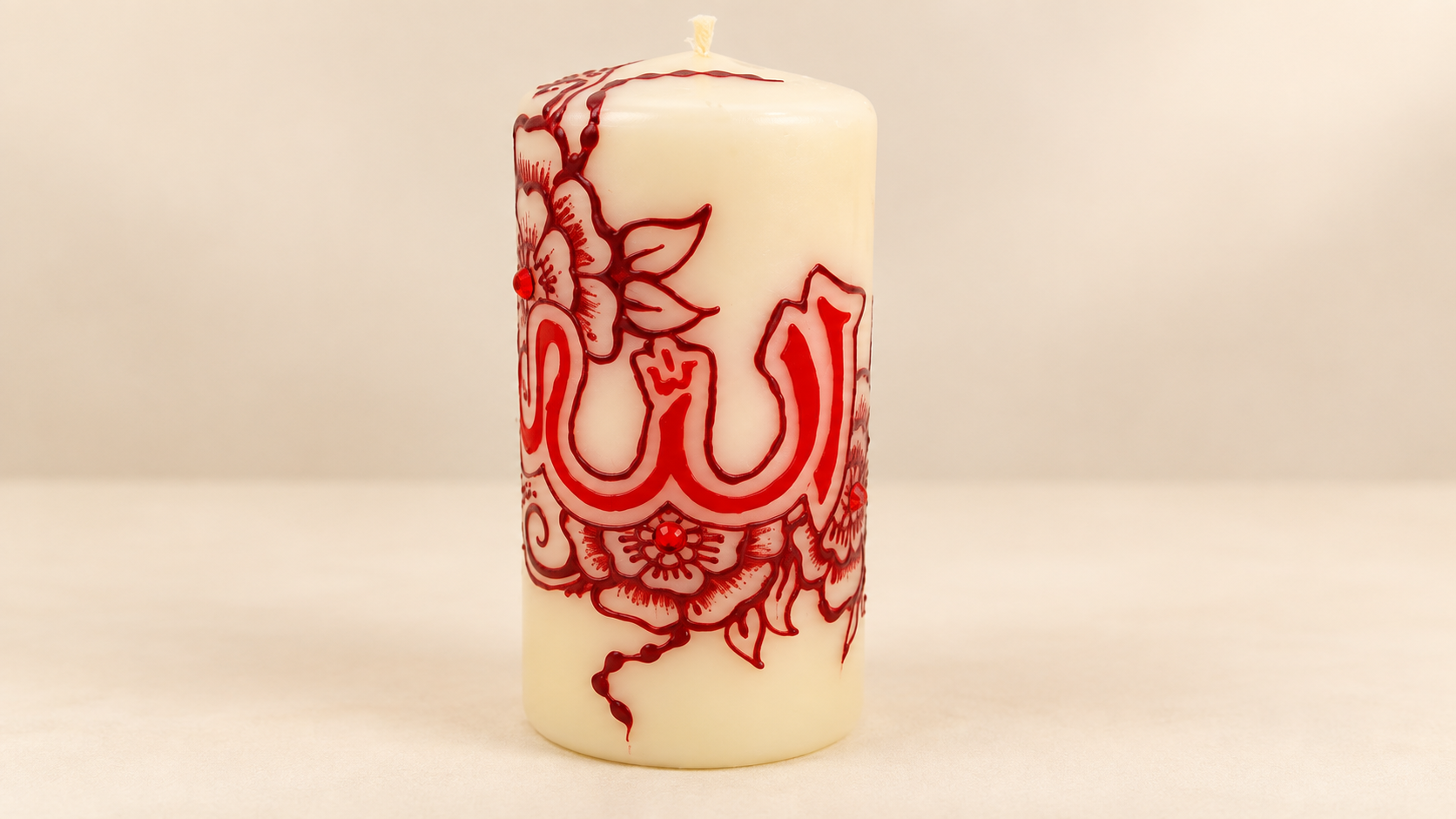 Crèmekleurige kaars met rode Arabische kalligrafie en henna bloemen
